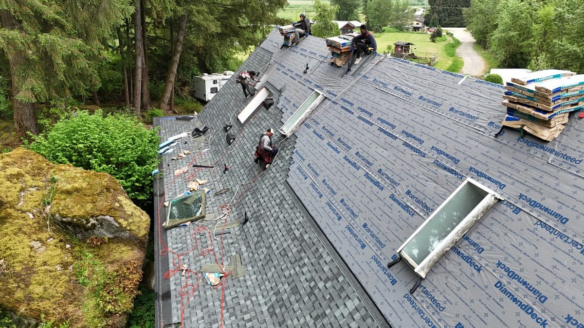 RR Roofing crew installing new asphalt shingles on a residential roof