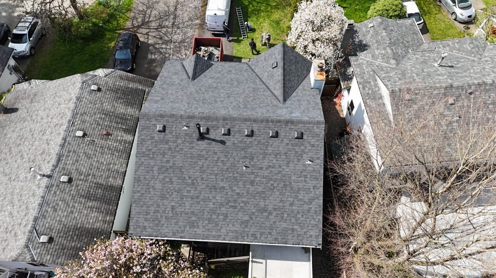 Fresh shingle roof with crew vehicles on site