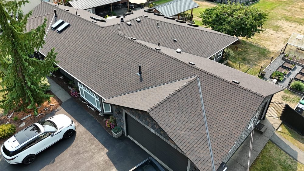 Completed brown asphalt shingle roof on a Fraser Valley home, aerial view