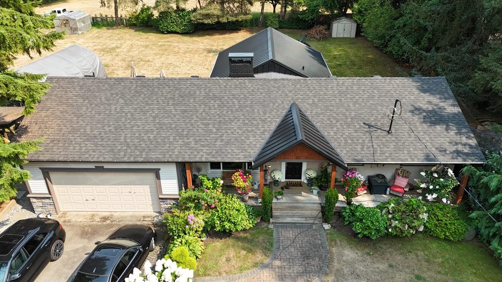 Finished shingle roof on a home with a covered front porch, aerial view