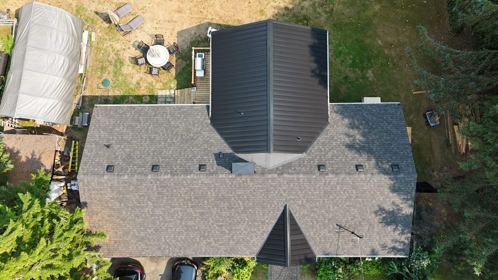 Asphalt shingle roof with a standing-seam metal section, overhead view