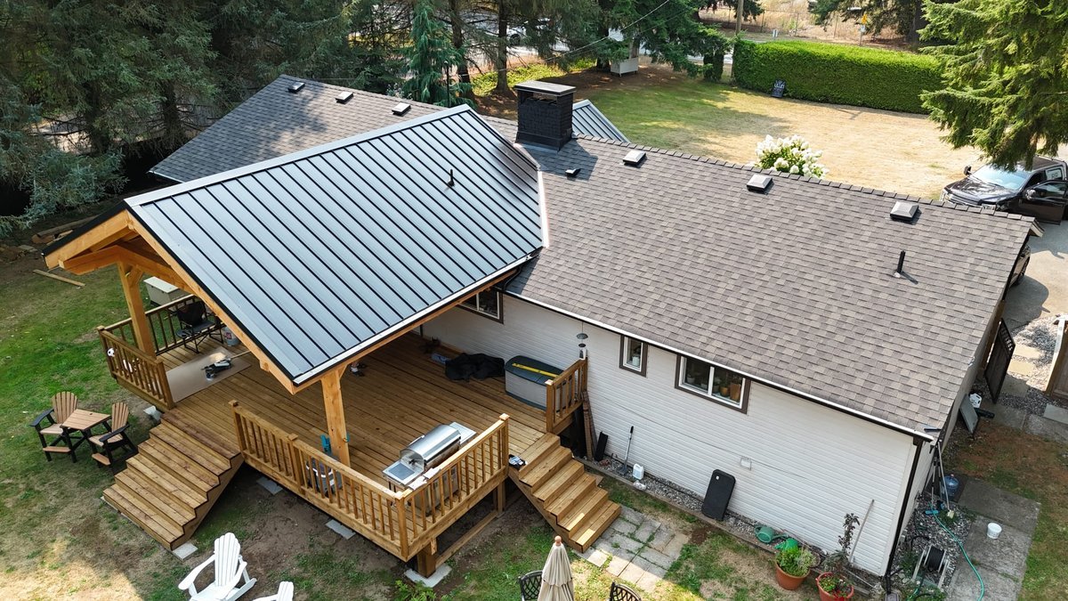 Standing-seam metal roof on a Fraser Valley home, over a cedar deck pavilion